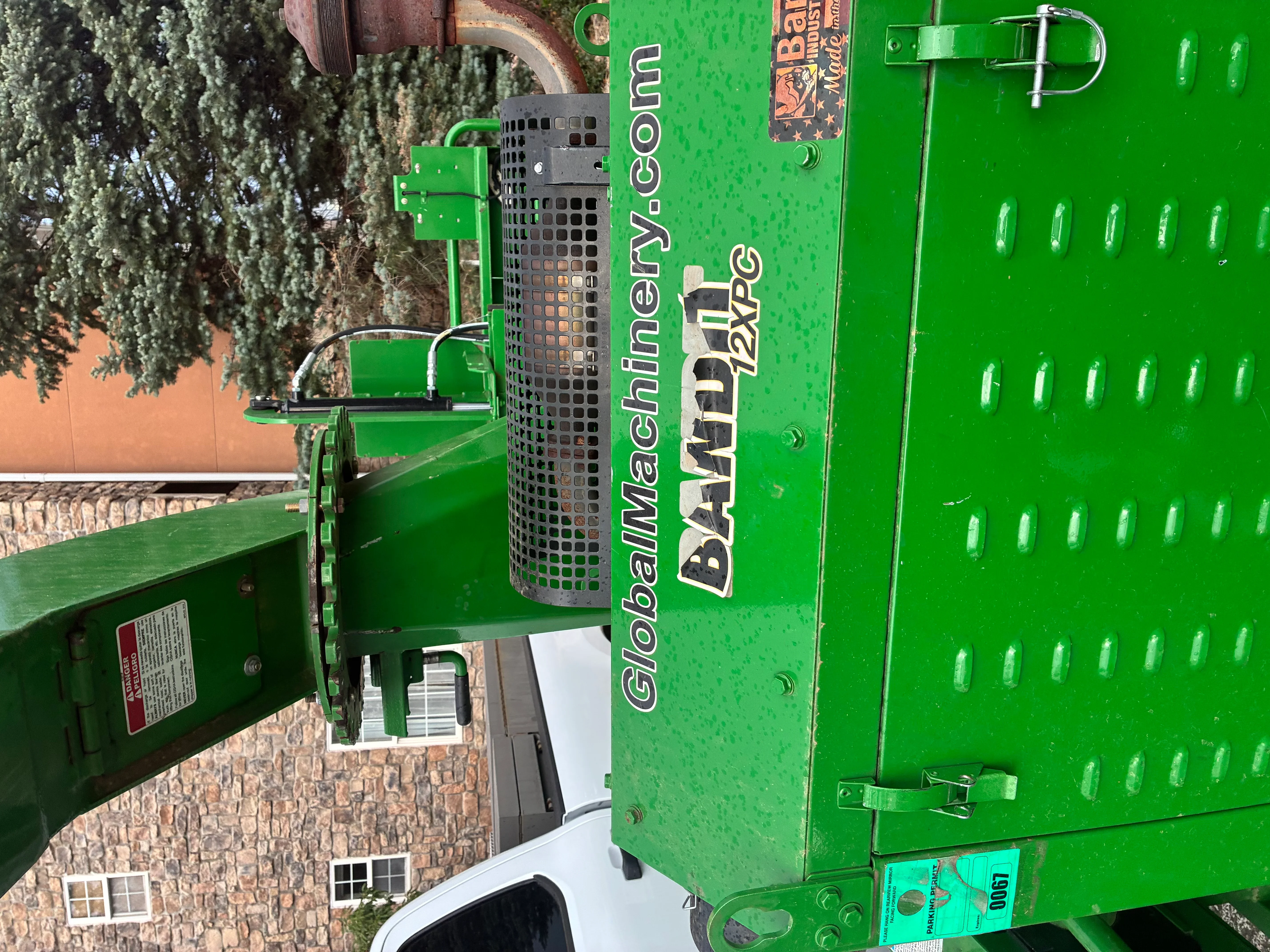 Green wood chipper with mesh hopper and discharge chute on trailer