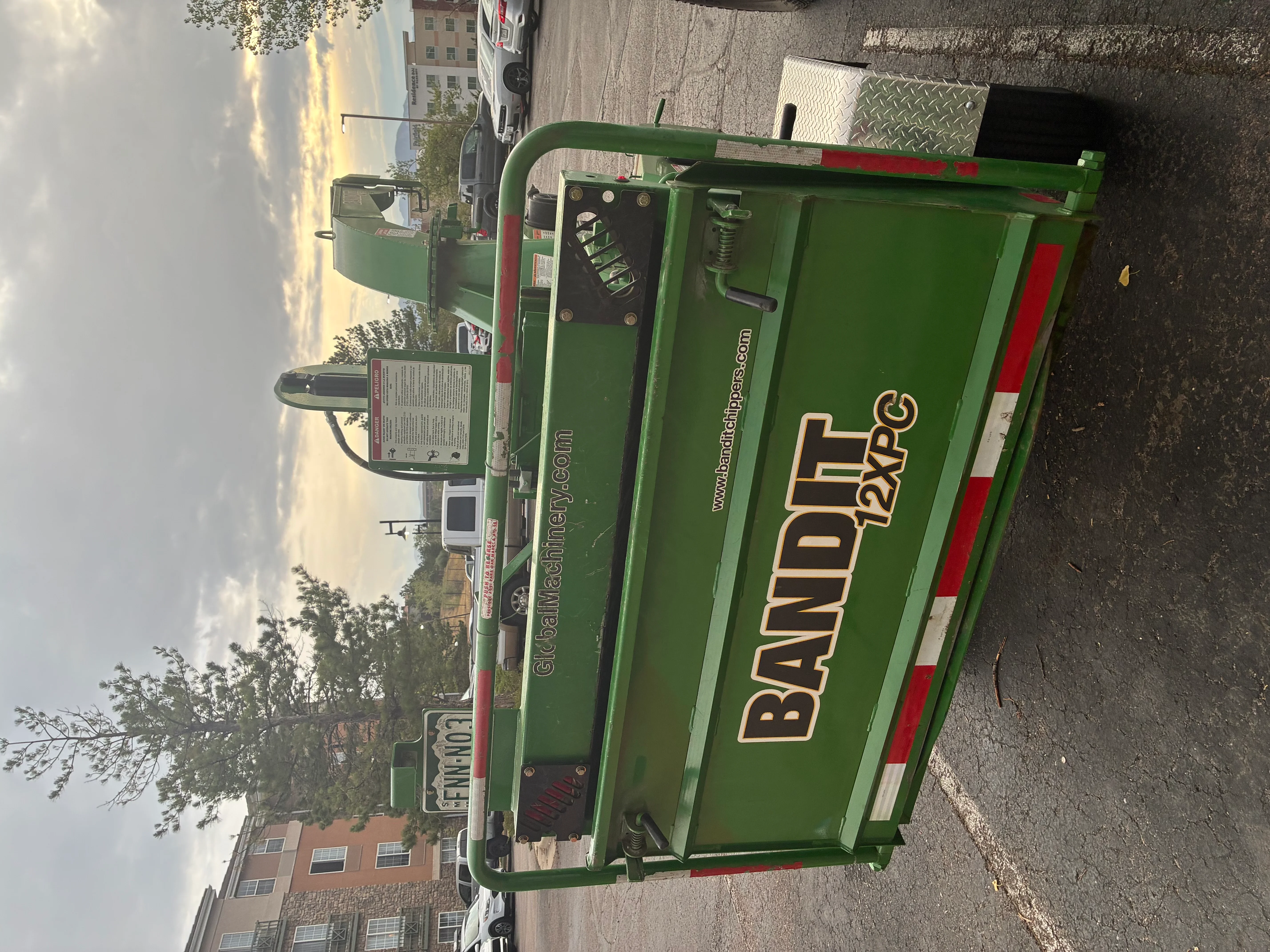 Green Bandite debris removal truck with red striping and industrial hopper system