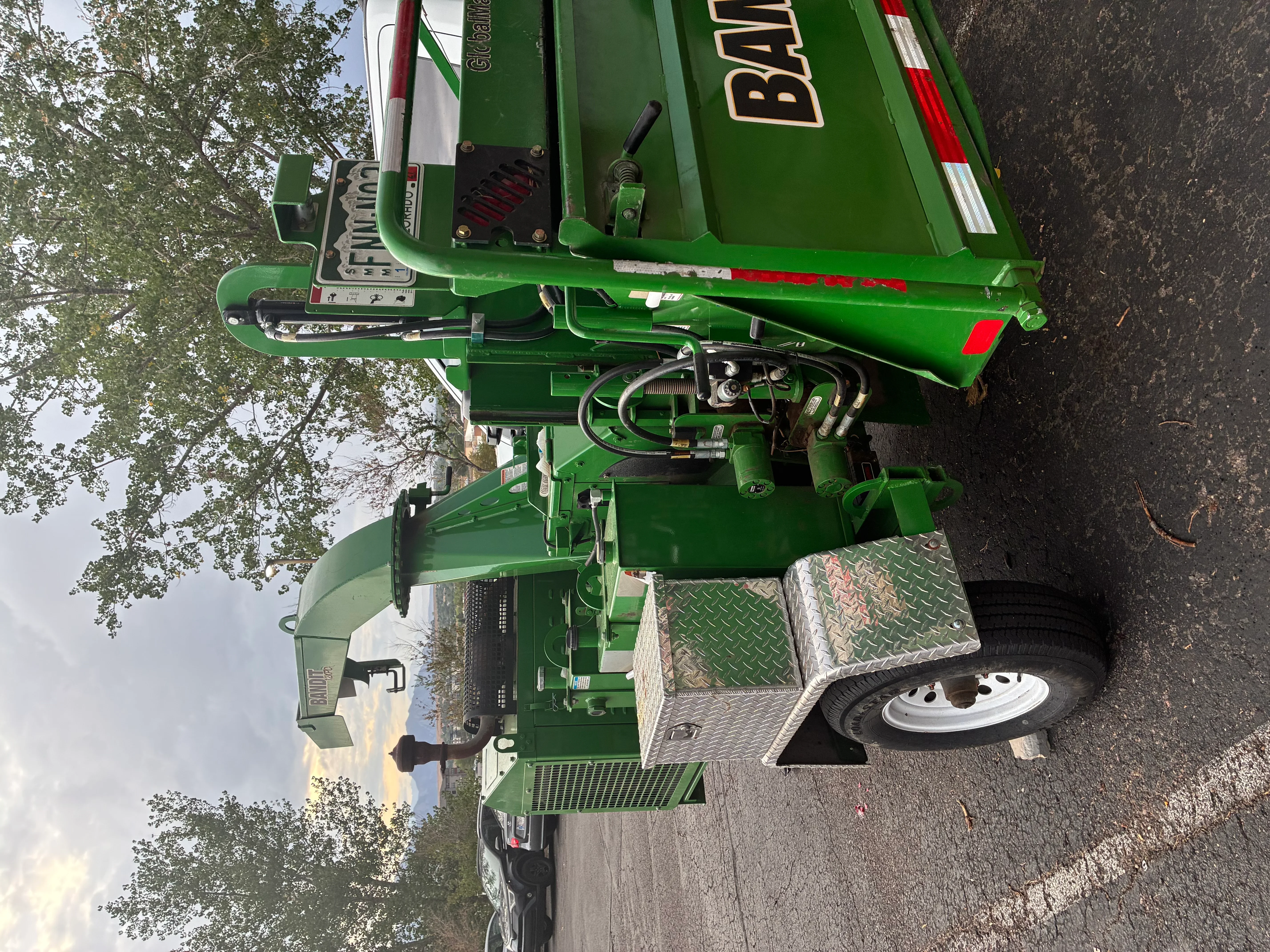 Green hydraulic stump grinder with diesel engine and remote control on trailer