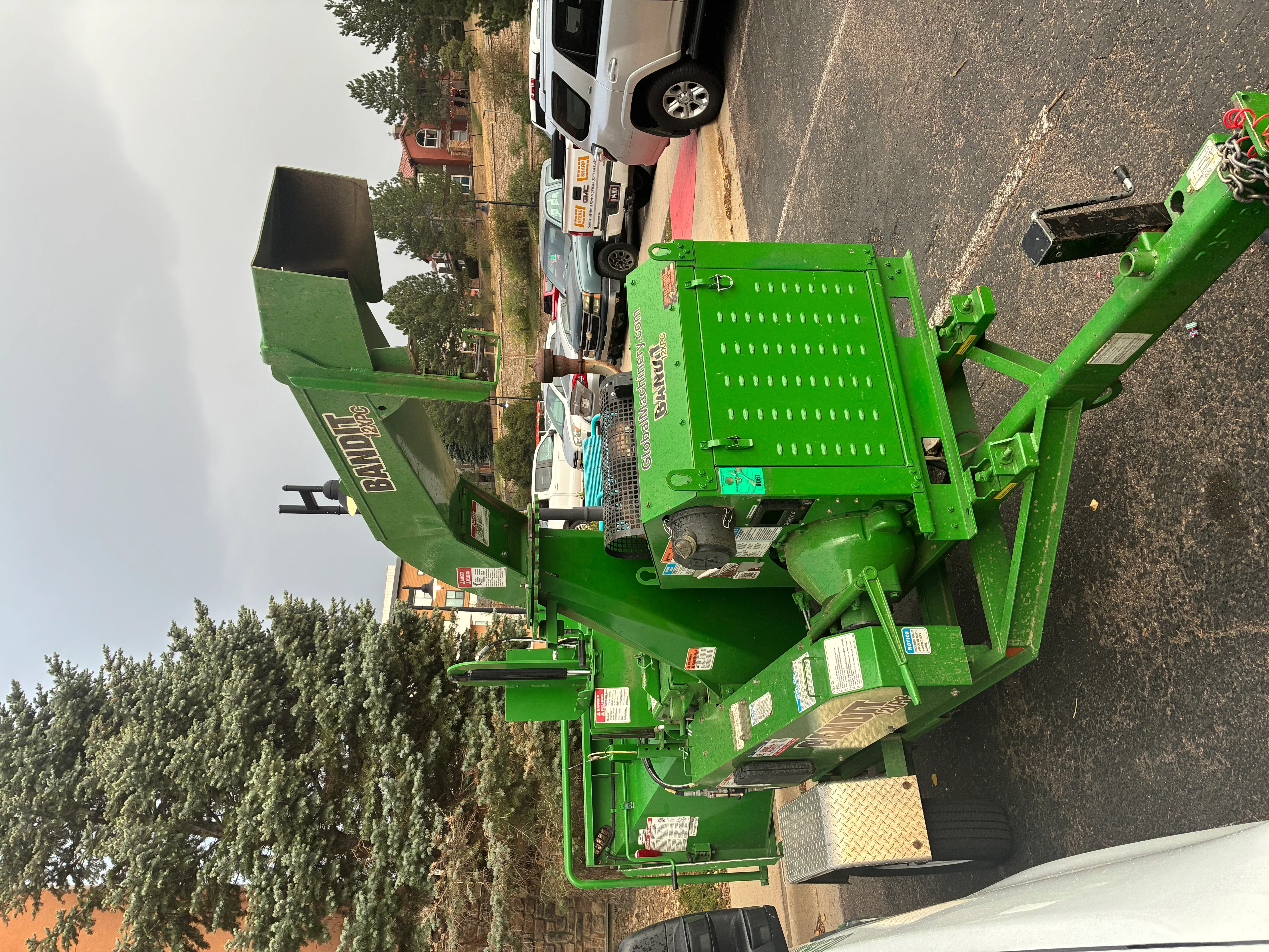 Green wood chipper with perforated hopper and adjustable discharge chute